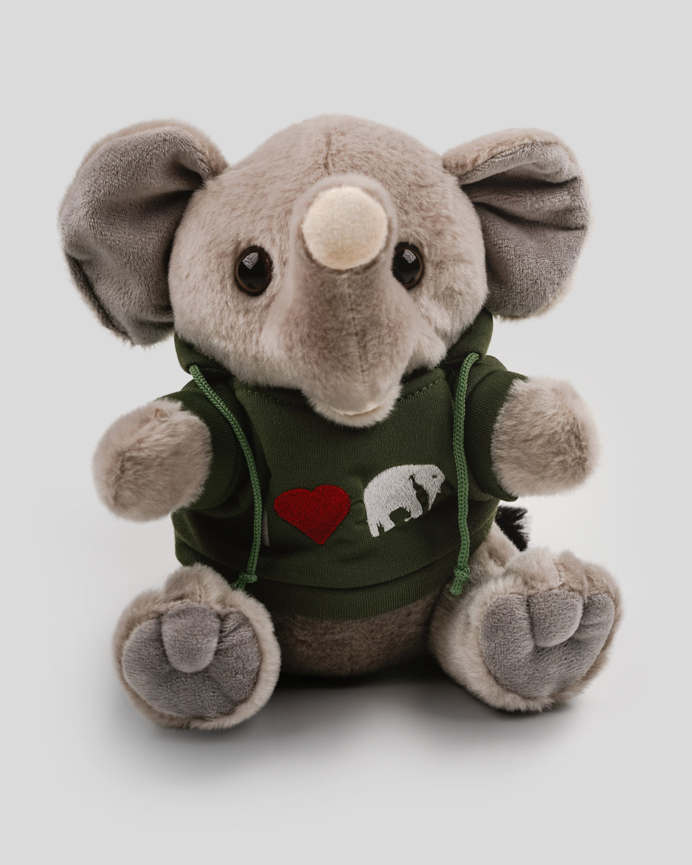 Graues Plüschelefant-Kuscheltier mit großen Ohren, rundem Körper und dunklen Knopfaugen. Der Elefant trägt einen dunkelgrünen Kapuzenpullover mit gesticktem Motiv: rotes Herz und weißes Elefantensymbol.