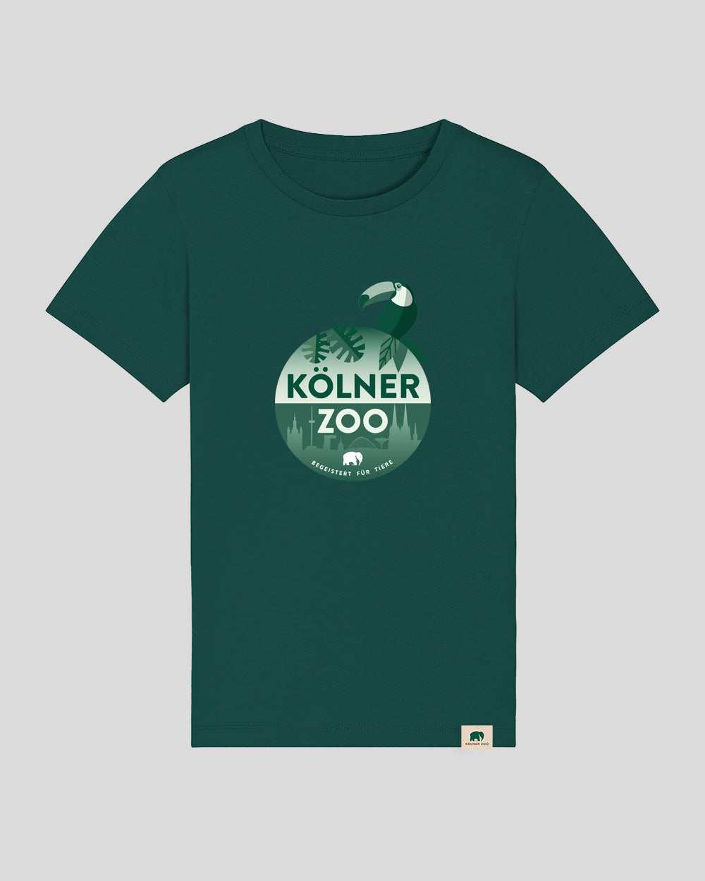 Dunkelgrünes Kurzarmshirt mit mittigem Runddruck in Grüntönen. Im Motiv: ein stilisierter Tukan sitzt auf einer Kugel mit der Aufschrift ‚Kölner Zoo – Begeistert für Tiere‘. Im Hintergrund sind Blätter und die Kölner Skyline angedeutet. Am Saum ist ein kleines Etikett mit Elefantensymbol eingenäht.
