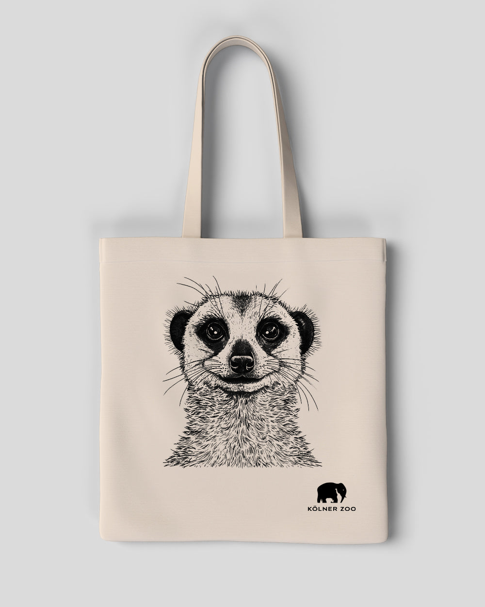 Beigefarbene Stofftasche mit naturgetreu gezeichneter Schwarz-Weiß-Illustration eines Erdmännchens auf der Vorderseite. Unten rechts befindet sich das Logo des Kölner Zoos mit einem stilisierten Elefanten und dem Schriftzug ‚Kölner Zoo‘.