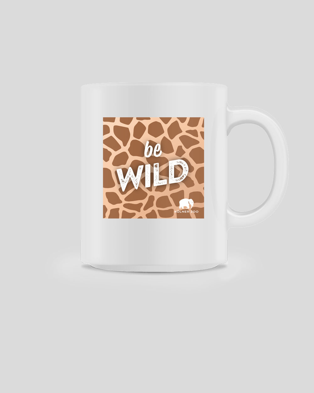 Weiße Keramiktasse mit quadratischem Aufdruck im Giraffenmuster. In der Mitte steht der Schriftzug ‚be WILD‘ in Weiß, teils mit rauer Textur. Unten rechts befindet sich das Logo des Kölner Zoos mit stilisiertem Elefanten.